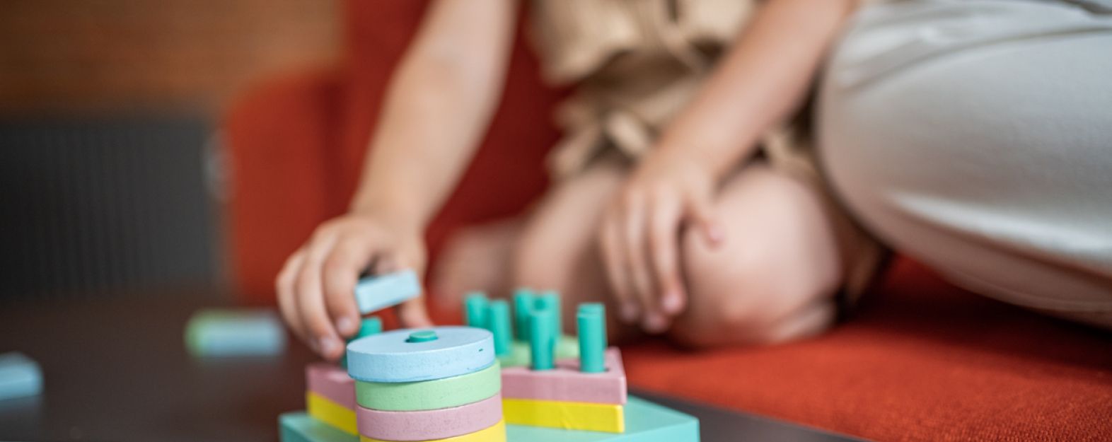 Young child placing blocks on a peg board