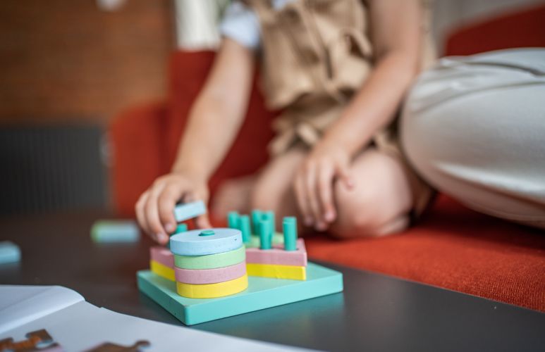 Young child placing blocks on a peg board