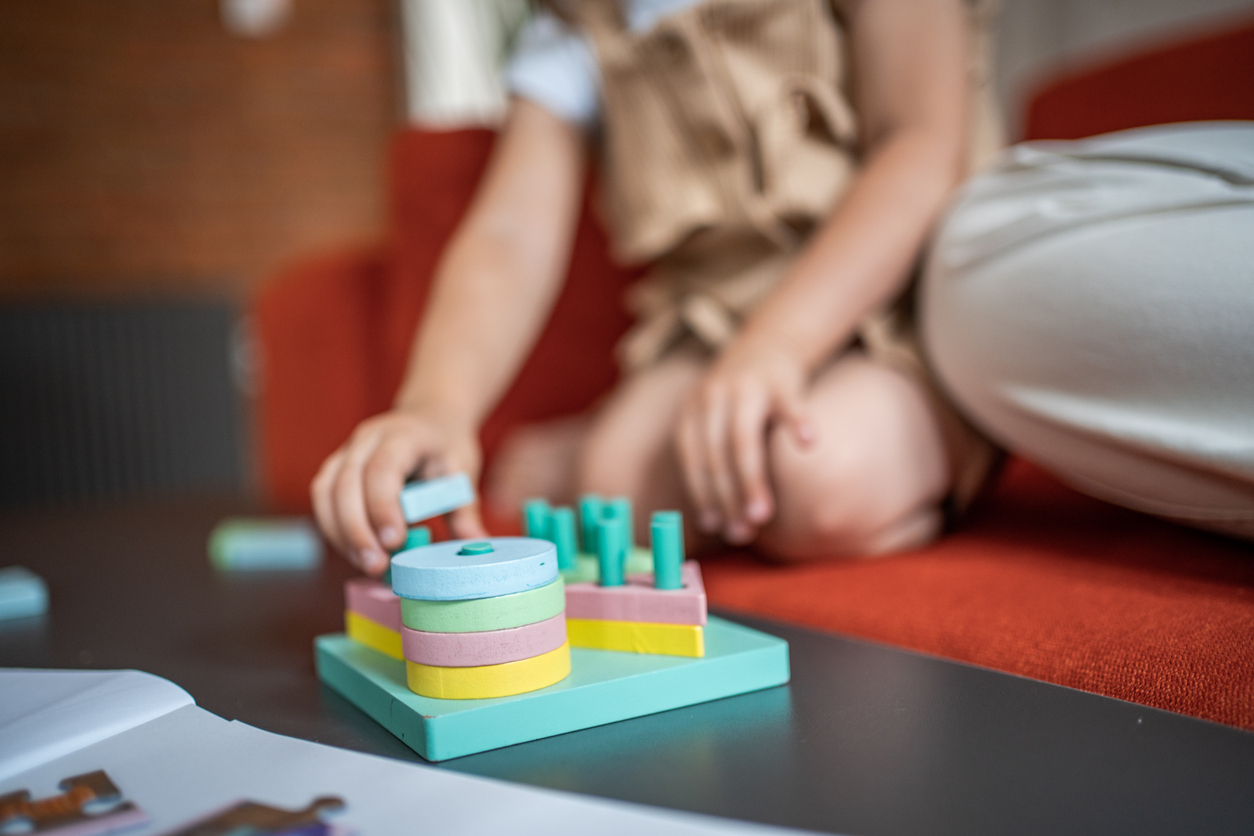 Young child placing blocks on a peg board