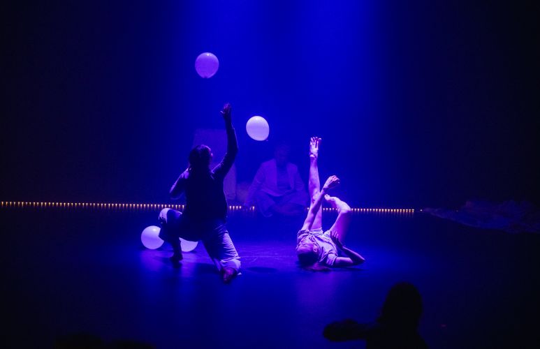 Performers on stage with balloons