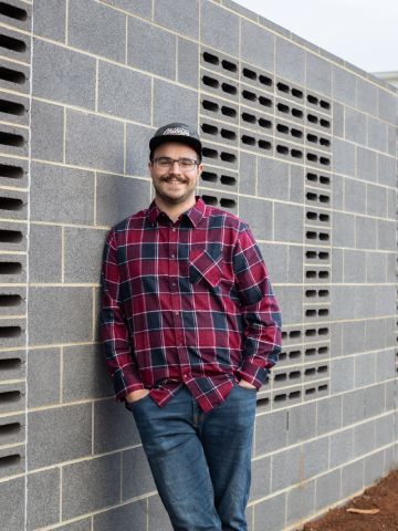 Man leaning against wall which has Hope spelled out