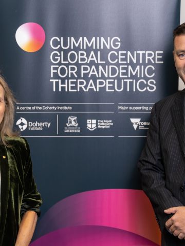 A womand and a man standign in front of a banner for the Cumming Global Centre for Pandemic Therapeutics