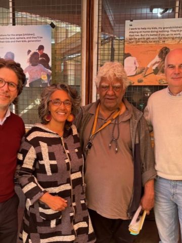 Three men and one woman standing next to each other facing the camera smiling. 