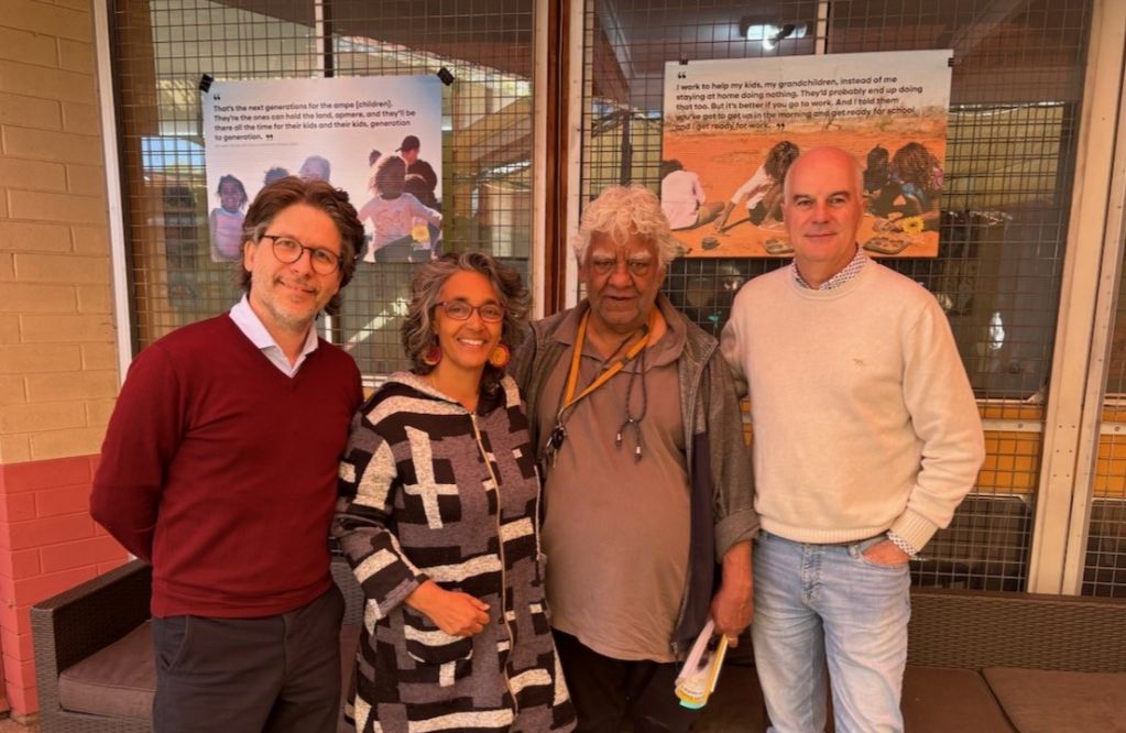 Three men and one woman standing next to each other facing the camera smiling. 