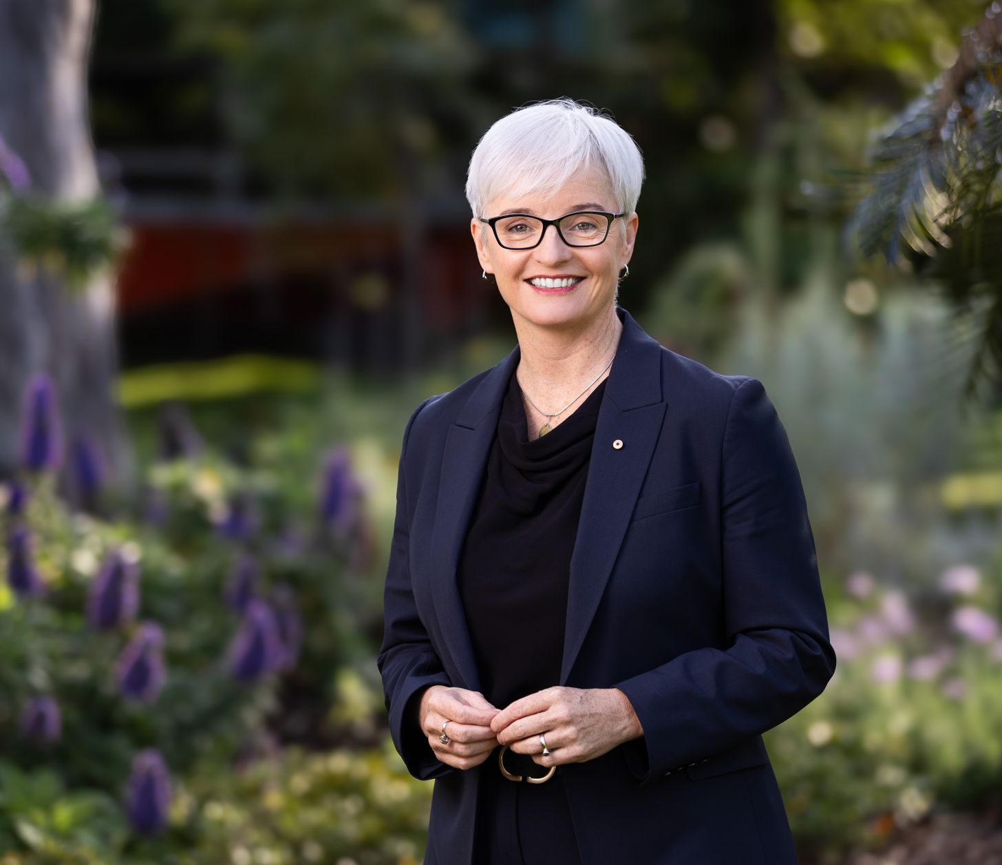 Middle-aged woman in dark jacket facing the camera and smiling