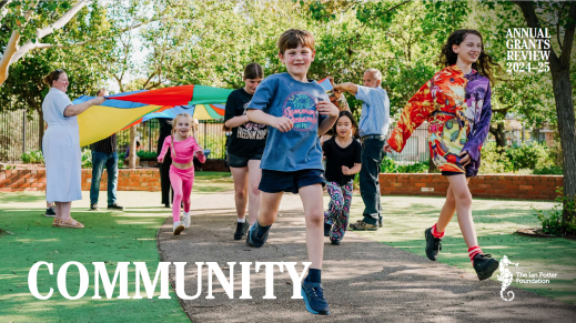 Children running under a parachute held by adults
