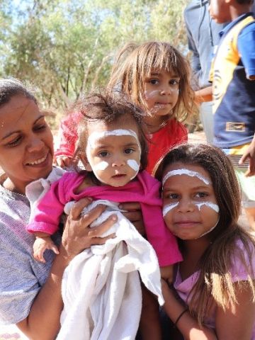 Indigenous mother with her three young children wearing white ochre