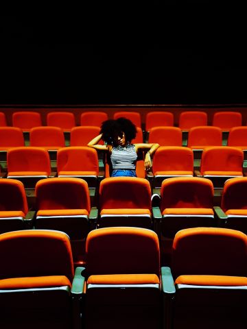 Woman sitting in empty theatre