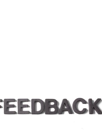 Cut-out jumbled alphabet letters with the word Feedback pulled out