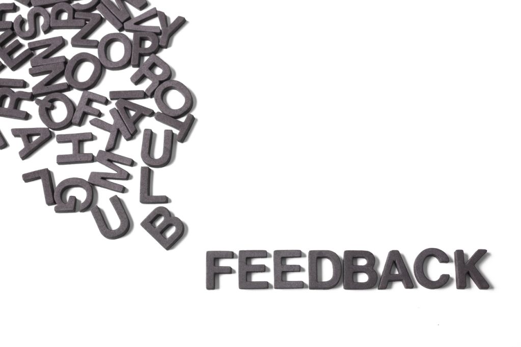 Cut-out jumbled alphabet letters with the word Feedback pulled out