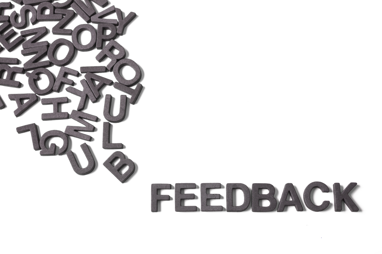 Cut-out jumbled alphabet letters with the word Feedback pulled out