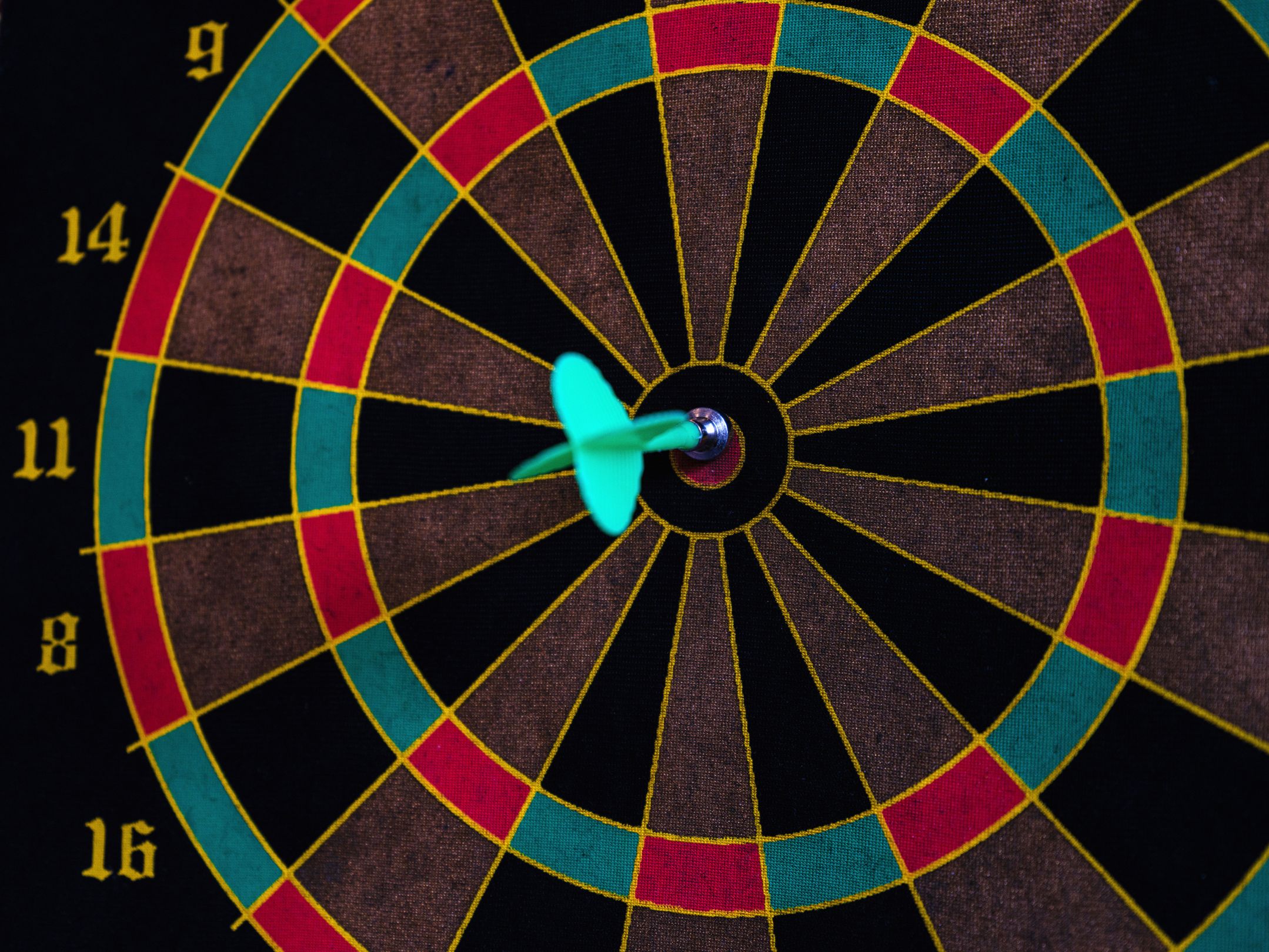 Dartboard with one dart in the bull-eye