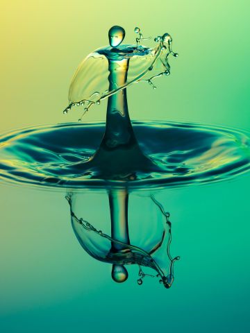 Water drop hitting water surface and reflected in water